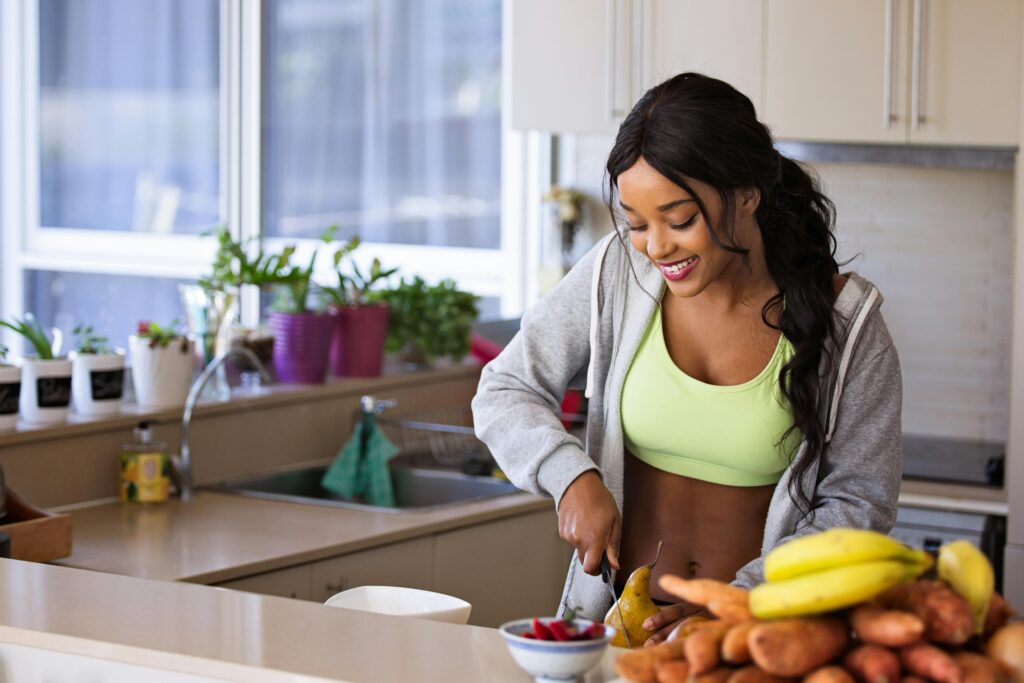 pexels photo 1153369 1153369 Smiling woman preparing fresh fruit in a sunlit kitchen, embodying a healthy lifestyle.